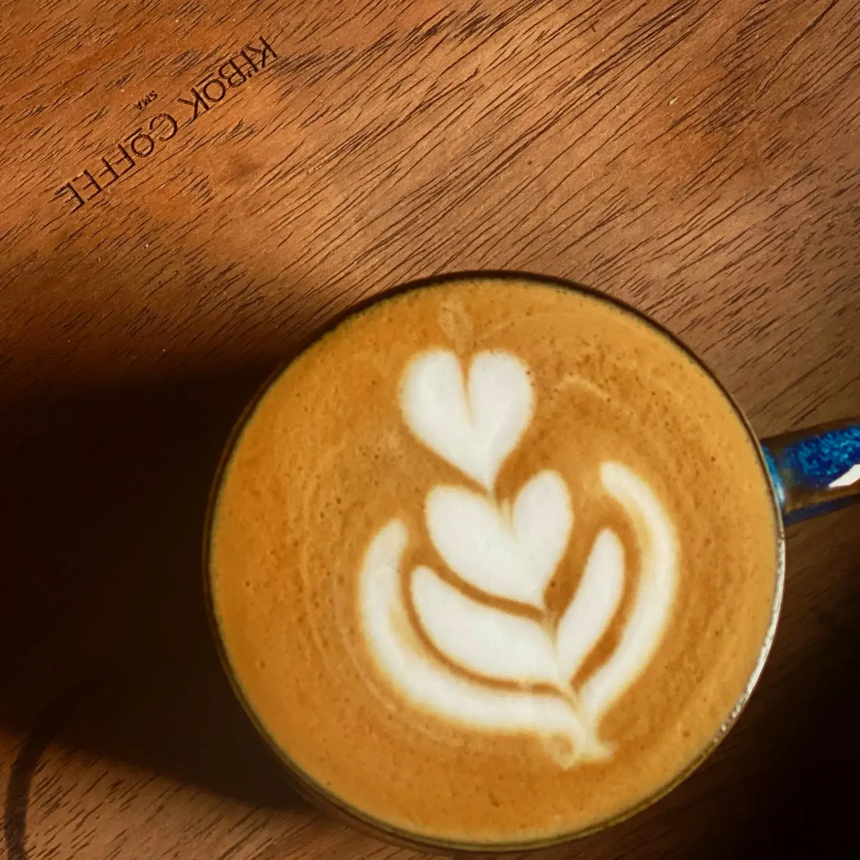 Ki'bok latte art heart pattern on branded espresso cup