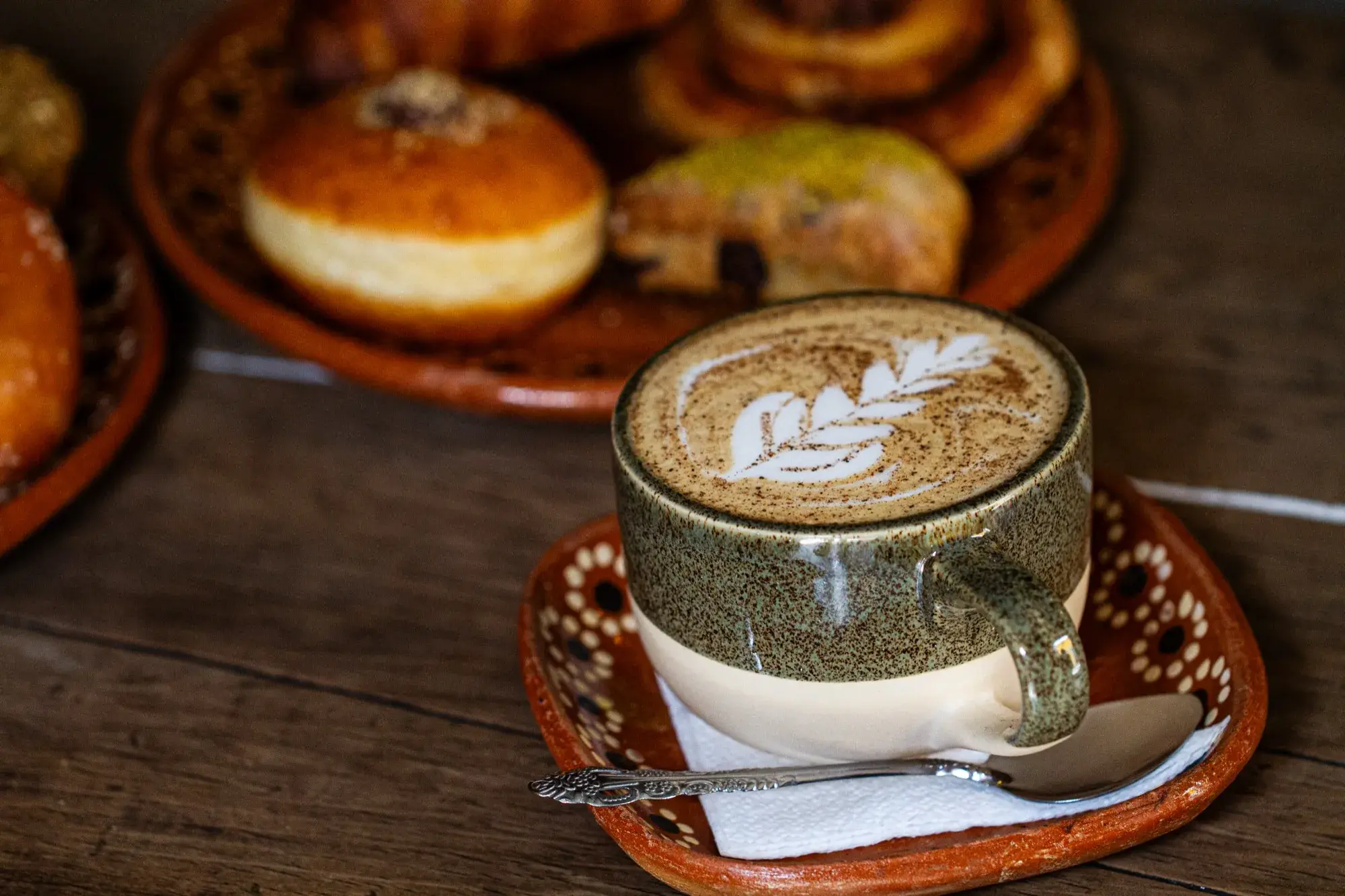 Overhead coffee and pastry pairing — latte art with fresh pastries at Ki'bok